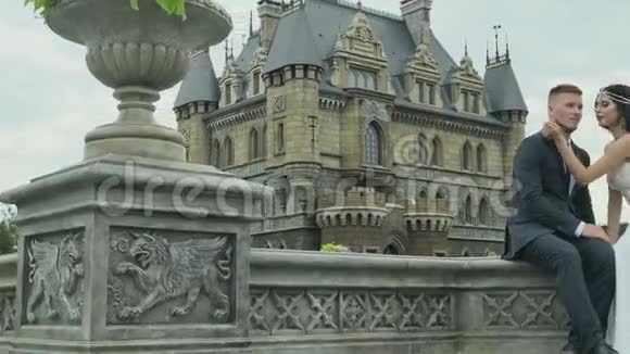 快乐美丽的新娘和新郎走在城堡附近视频的预览图