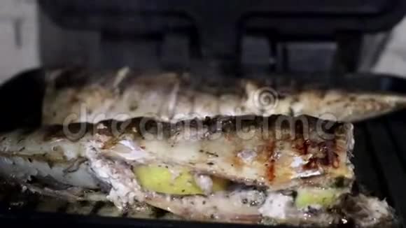 鲭鱼是在电烤架上烤的加柠檬和沙拉的烤鱼视频的预览图