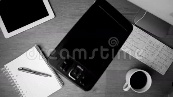 黑色和白色的智能手机落在办公桌上视频的预览图