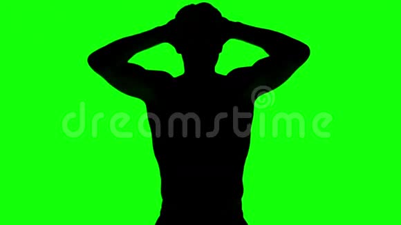一个男人在绿色屏幕上用手绷紧的剪影视频的预览图