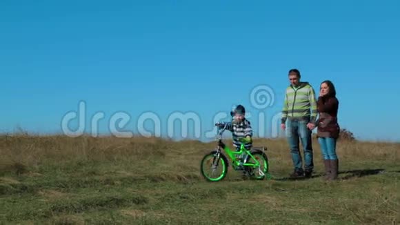 秋天骑自行车的孩子快乐的年轻家庭视频的预览图