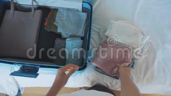 年轻女子正在收集一个手提箱准备旅行的旅行者视频的预览图