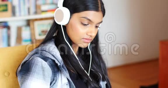带着耳机听数字平板电脑音乐的女人视频的预览图