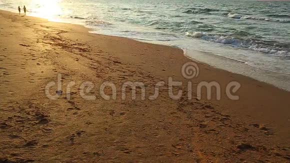 日落时分两个孩子在海滩上奔跑视频的预览图