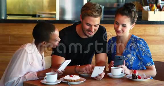 朋友在吃早餐和咖啡时使用手机视频的预览图