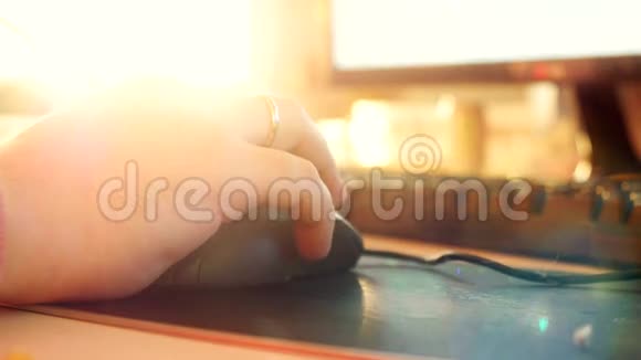 关闭男性手在电脑键盘和鼠标打字与改变焦点和镜头耀斑与阳光4k视频的预览图