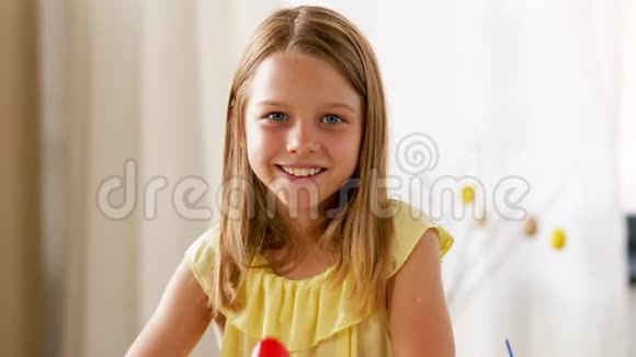 快乐的女孩在家里展示彩色复活节彩蛋视频的预览图