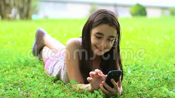 小女孩在智能手机上玩得很开心视频的预览图