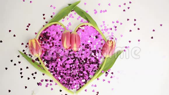 以郁金香为背景的粉红色五彩纸屑制成的心脏视频的预览图