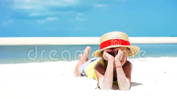 加勒比海度假期间在海滩上戴帽子的小可爱女孩下面的动作视频的预览图