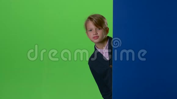 十几岁的孩子在绿色的屏幕上从黑板后面偷看视频的预览图