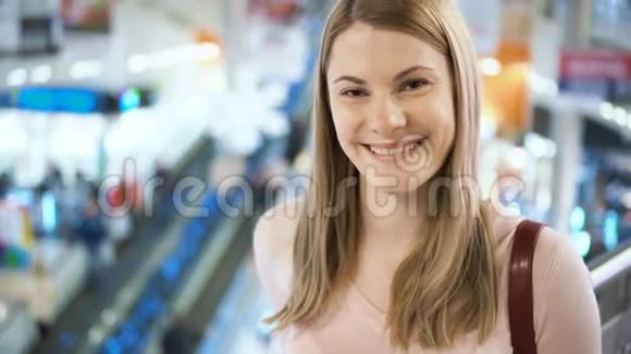 美丽迷人的年轻女子站在商场里微笑着购物消费主义概念视频的预览图