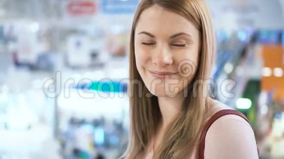 年轻漂亮迷人的女人站在商场里微笑着购物消费主义概念视频的预览图