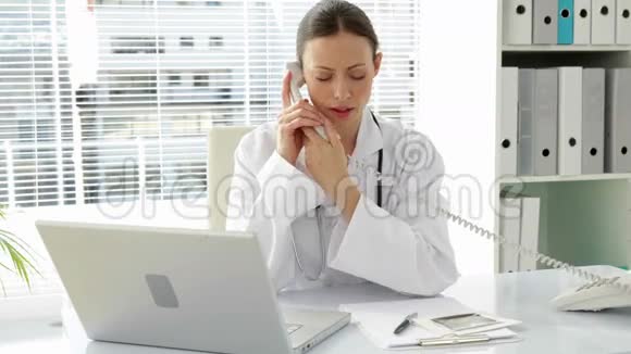 医生在桌旁打电话视频的预览图
