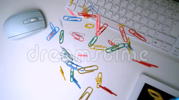 五颜六色的纸夹落在白色办公桌的中间视频的预览图