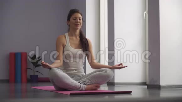 瑜伽女孩冥想用手做一个禅宗符号视频的预览图