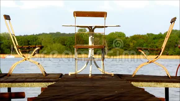 三把旧椅子和一张桌子在码头上视频的预览图