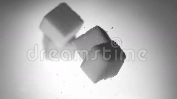 四个糖块落在白色表面视频的预览图