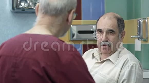 医生在办公室和老年男性病人谈话视频的预览图