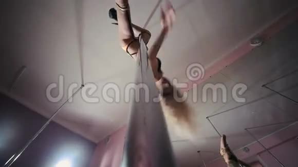 金发女郎在舞蹈室的杆子上跳舞视频的预览图