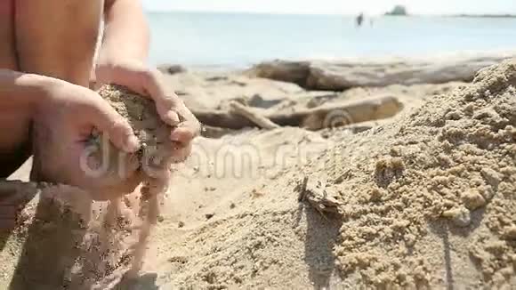 在阳光明媚的日子里小男孩在沙滩上和海浪中缓慢地玩耍视频的预览图