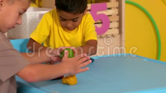可爱的小男孩在教室里玩粘土模型视频的预览图