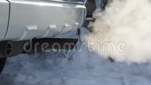 消声器运转车产生的废气在冬季道路上行驶的汽车的轮子视频的预览图