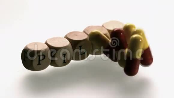 药物胶囊落在骰子拼写药丸前面视频的预览图