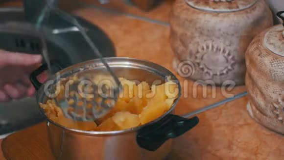 将土豆捣碎在厨房的锅中视频的预览图
