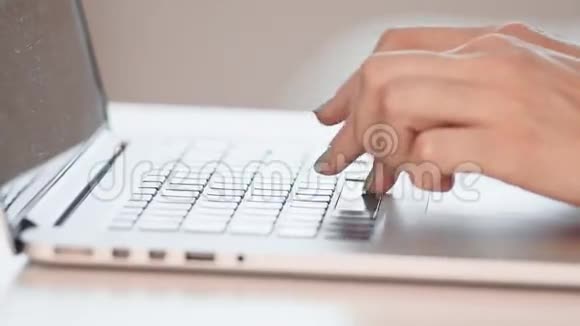 在笔记本电脑上工作的年轻女人的特写慢动作视频的预览图