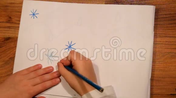 近距离观看儿童手在纸上的绘画用蓝色铅笔画星星视频的预览图