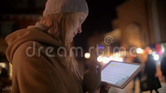 晚街使用平板电脑的年轻女子视频的预览图