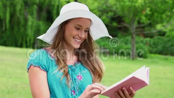 快乐的年轻女子在读一本迷人的书视频的预览图