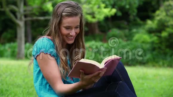 微笑的女人读着一本迷人的小说视频的预览图