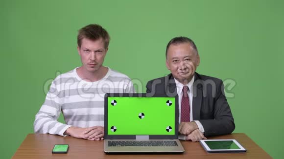 成熟的日本商人和年轻的斯堪的纳维亚商人一起工作视频的预览图