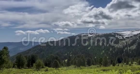 山顶后面云景的时间流逝雪岩石悬崖和深蓝色的天空高空视频的预览图