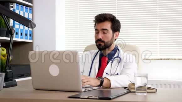 他办公室里的医生在电脑上工作视频的预览图