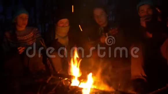 晚上坐在篝火旁弹吉他的年轻朋友视频的预览图