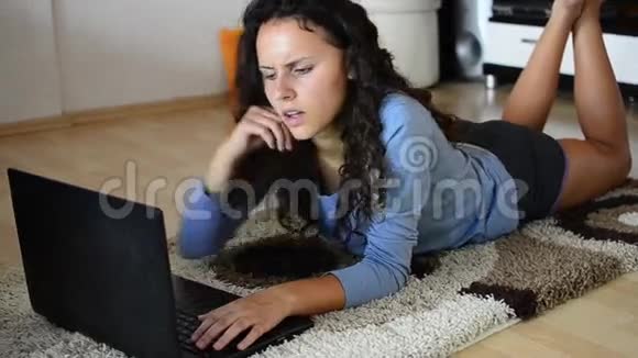 女孩躺在客厅里用笔记本电脑视频的预览图