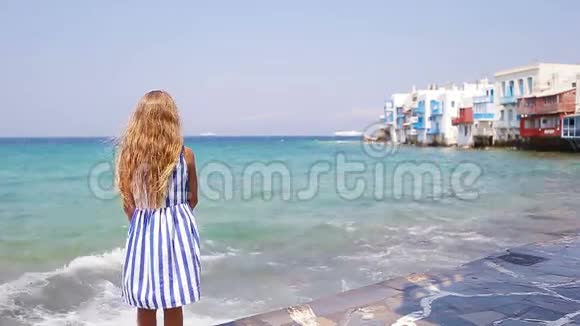 可爱的小女孩在小威尼斯最受欢迎的旅游区米科诺斯岛希腊美丽的孩子微笑视频的预览图