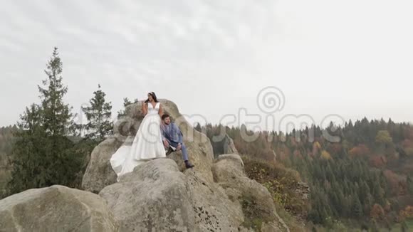 新婚夫妇站在山的高坡上新郎和新娘视频的预览图