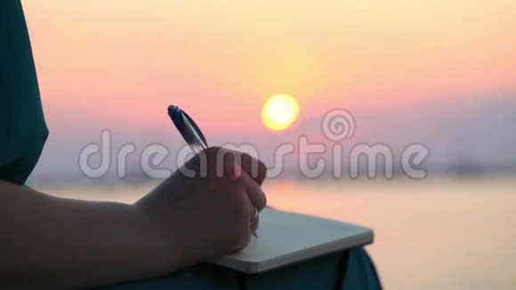 女人在日落时分写日记视频的预览图