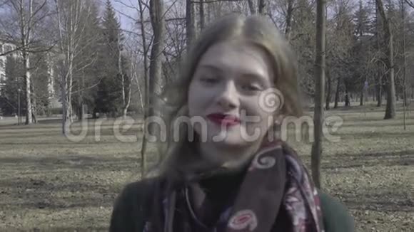 可爱的卷发女孩穿过公园视频的预览图