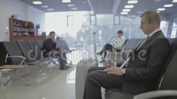 英俊的商人在机场候机厅等候登机视频的预览图