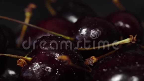 樱桃成熟的樱桃在黑色背景上旋转旋转黑色成熟甜樱桃旋转4KUHD视频无缝视频的预览图