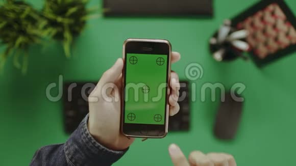 使用绿色屏幕智能手机的人的间接镜头视频的预览图