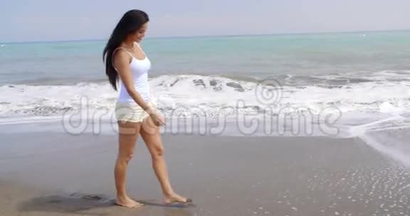 沿着热带海滩海岸漫步的女人视频的预览图