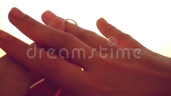 在夕阳的城市背景下新郎在新娘的手指上滑动戒指1920x1080视频的预览图