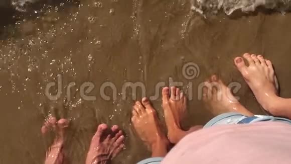 男孩女孩和男人家庭腿水在海洋慢动作视频强浪沙海休息家庭视频的预览图