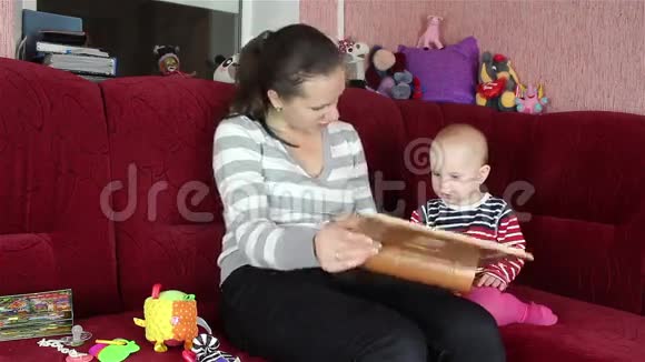年轻的妈妈和宝宝一起看书视频的预览图
